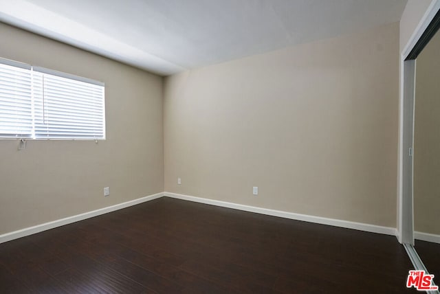 spare room with dark hardwood / wood-style flooring