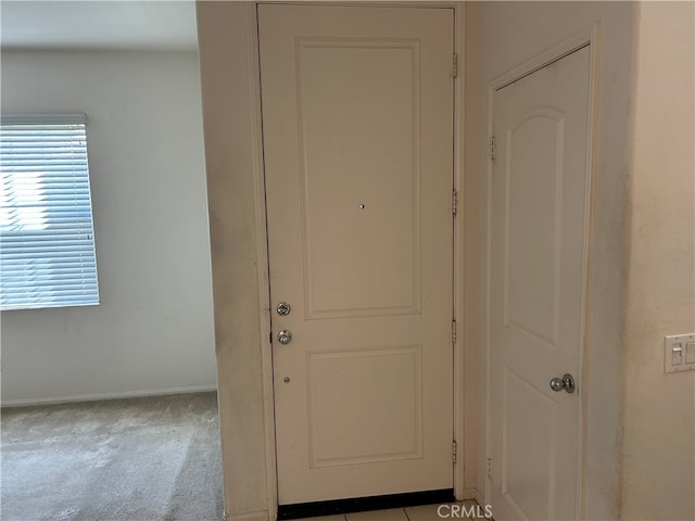 entryway featuring light colored carpet