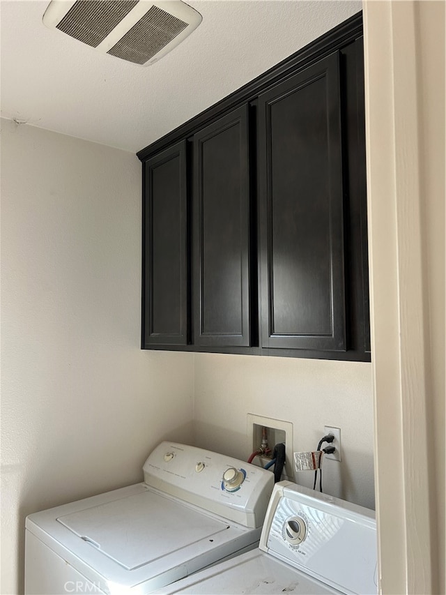 laundry area with washer and dryer and cabinets