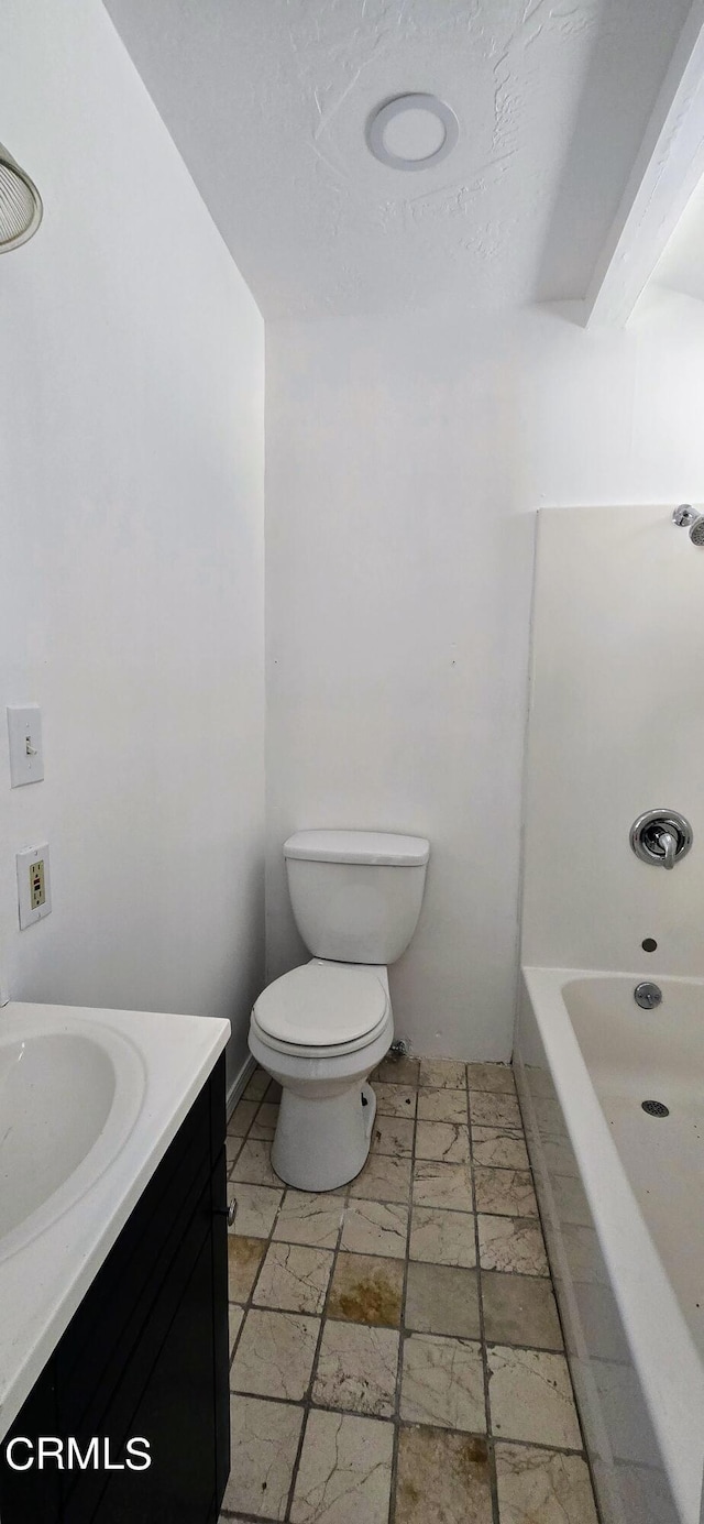 bathroom featuring a bath, vanity, and toilet