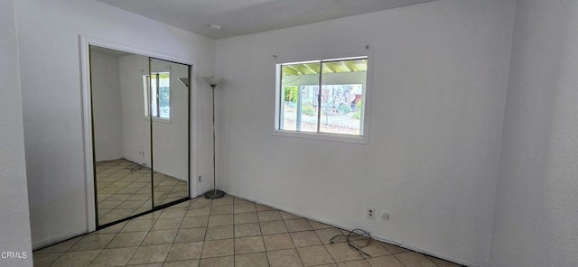 unfurnished bedroom featuring light tile patterned flooring and a closet