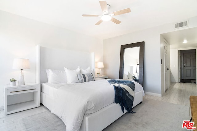 bedroom with light hardwood / wood-style floors and ceiling fan