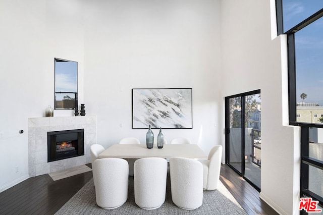 dining area featuring a tile fireplace and wood-type flooring