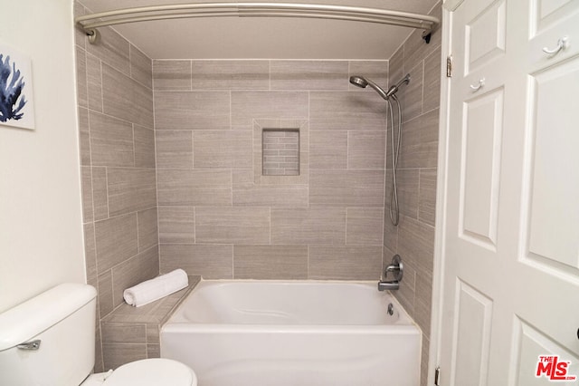 bathroom with toilet and tiled shower / bath