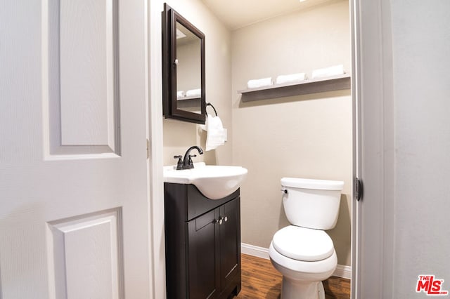 bathroom featuring hardwood / wood-style floors, vanity, and toilet