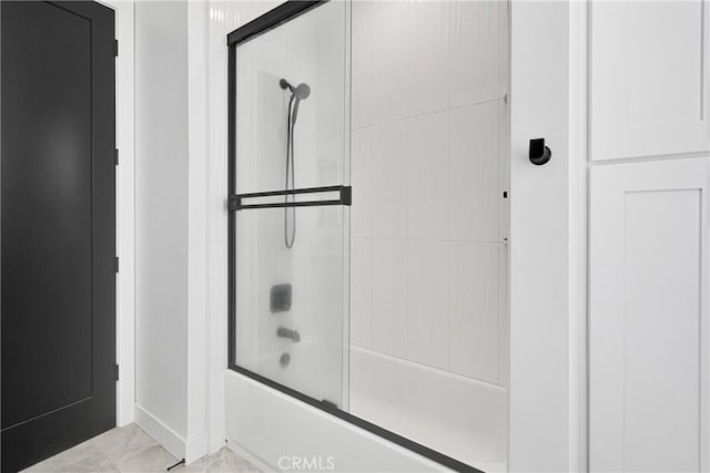 bathroom with combined bath / shower with glass door