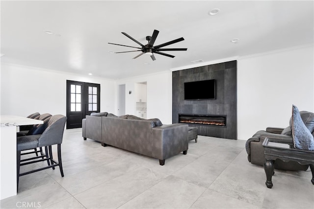 living room with ceiling fan, light tile patterned flooring, french doors, a fireplace, and crown molding