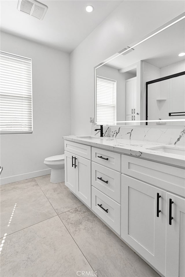 bathroom with tile patterned flooring, toilet, walk in shower, and vanity