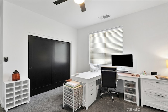 carpeted office space with ceiling fan