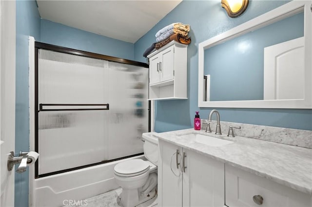 full bathroom featuring enclosed tub / shower combo, vanity, and toilet