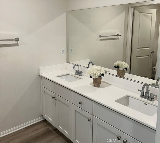 bathroom featuring vanity, hardwood / wood-style flooring, and toilet