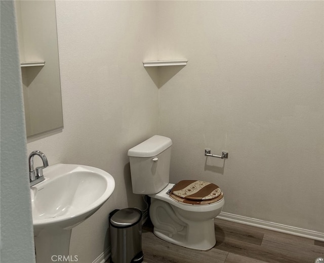 bathroom with hardwood / wood-style flooring, toilet, and sink