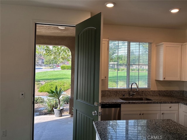 kitchen with white cabinetry, sink, dishwasher, and a healthy amount of sunlight