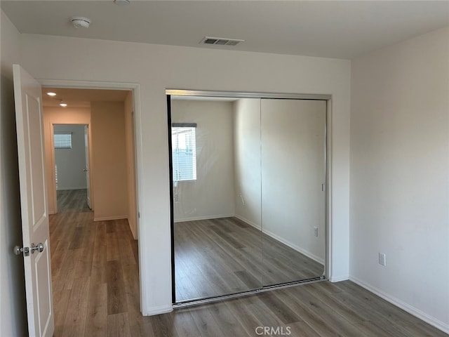 unfurnished bedroom with a closet and wood-type flooring