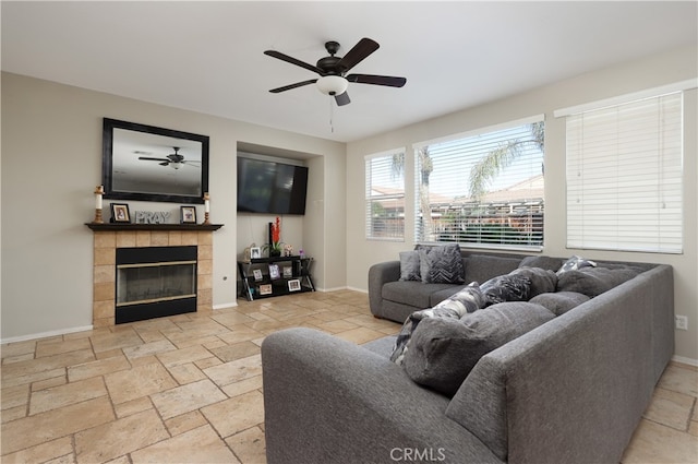 living room with ceiling fan and a tiled fireplace