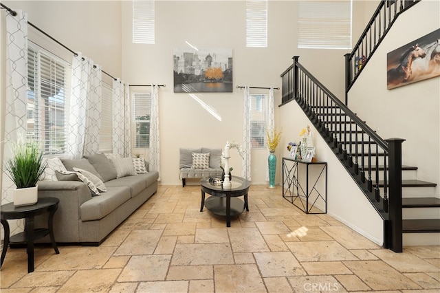 living room featuring a towering ceiling and a wealth of natural light