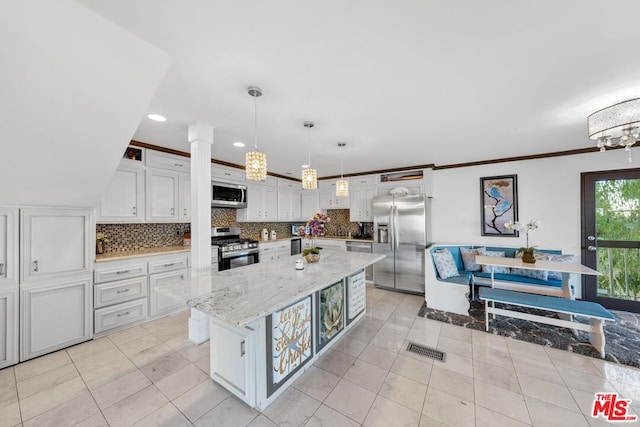 kitchen featuring tasteful backsplash, a kitchen island, decorative light fixtures, white cabinetry, and stainless steel appliances