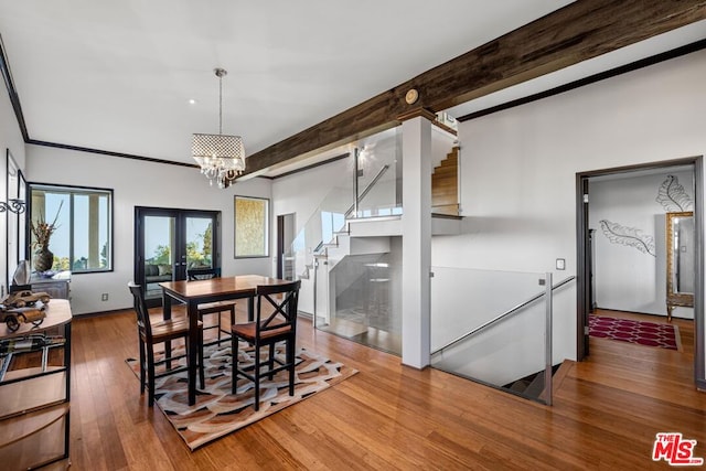 dining area featuring hardwood / wood-style flooring, a notable chandelier, beam ceiling, and french doors