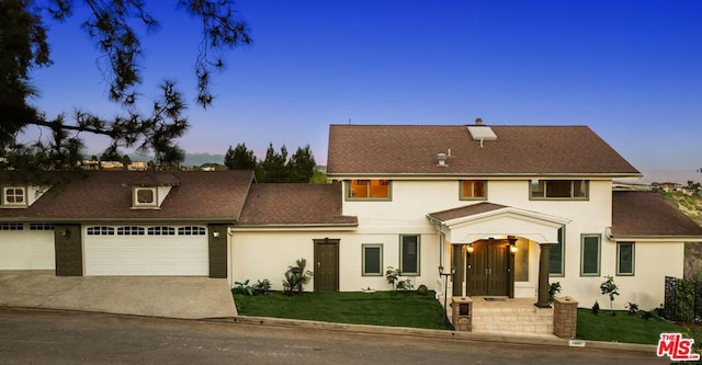 view of front of house featuring a garage and a yard