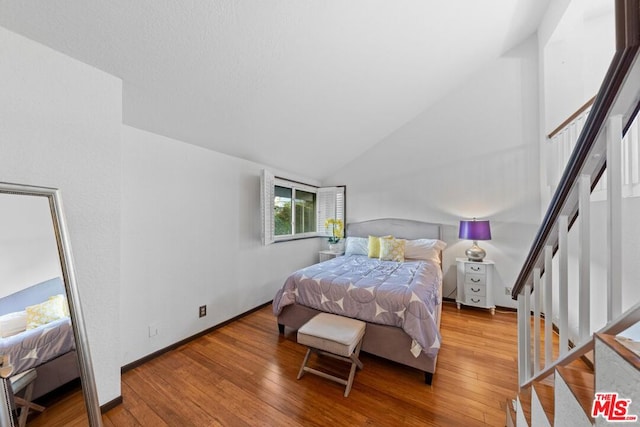 bedroom featuring light wood-type flooring and lofted ceiling