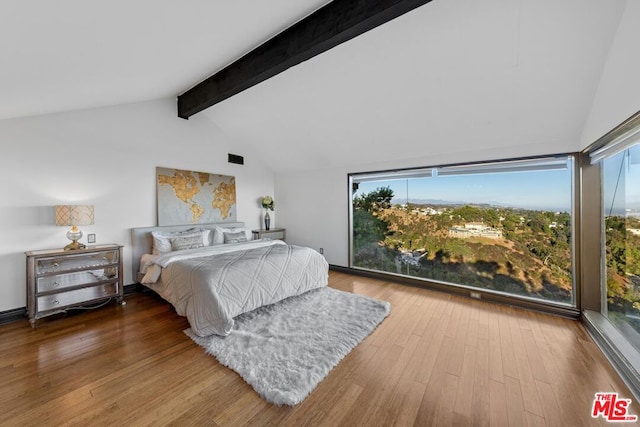 bedroom featuring wood-type flooring and lofted ceiling with beams