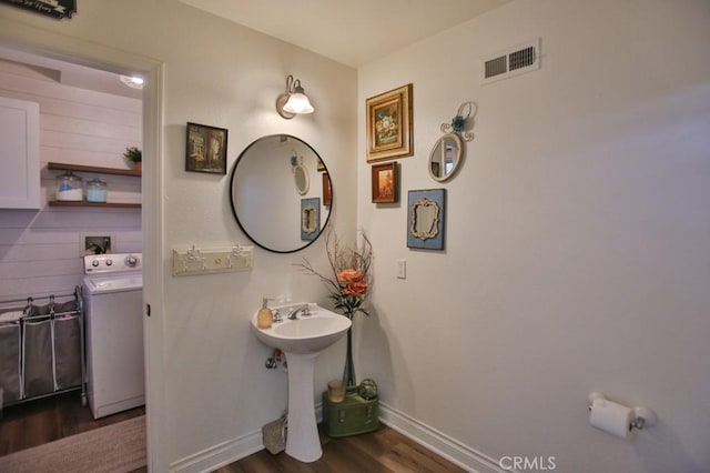 bathroom with washer / dryer and hardwood / wood-style flooring