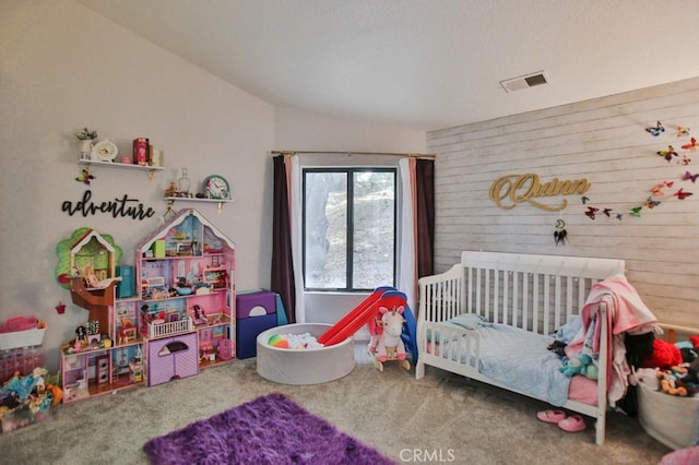 bedroom with wood walls, carpet flooring, and visible vents