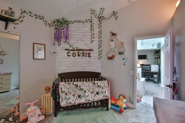 bedroom with a nursery area, carpet flooring, and radiator