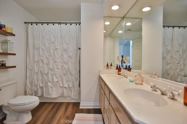 bathroom featuring double vanity, shower / bathtub combination with curtain, a sink, and wood finished floors