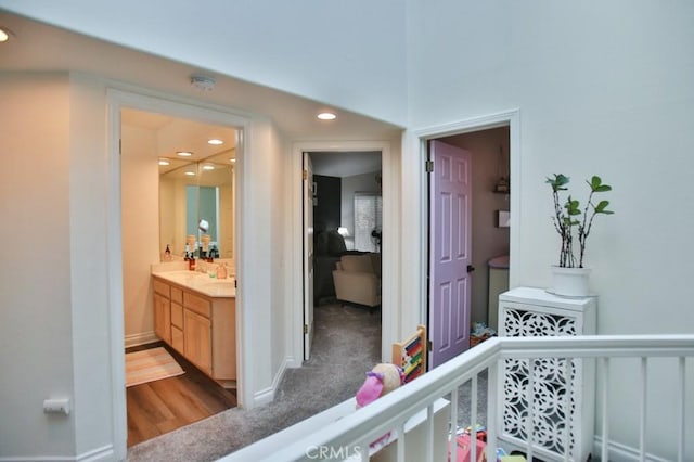 bedroom with light carpet, a dry bar, baseboards, a sink, and recessed lighting