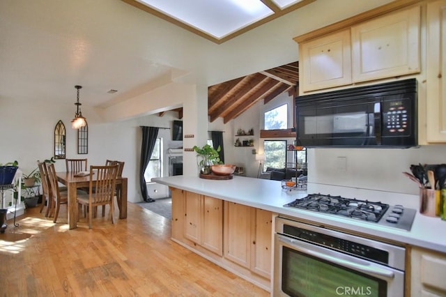 kitchen featuring vaulted ceiling with beams, light wood-style flooring, stainless steel appliances, hanging light fixtures, and light countertops