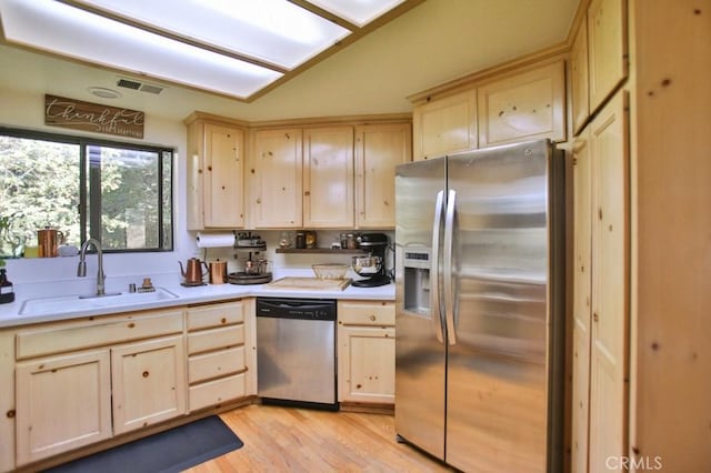 kitchen featuring visible vents, appliances with stainless steel finishes, light countertops, light wood-type flooring, and a sink