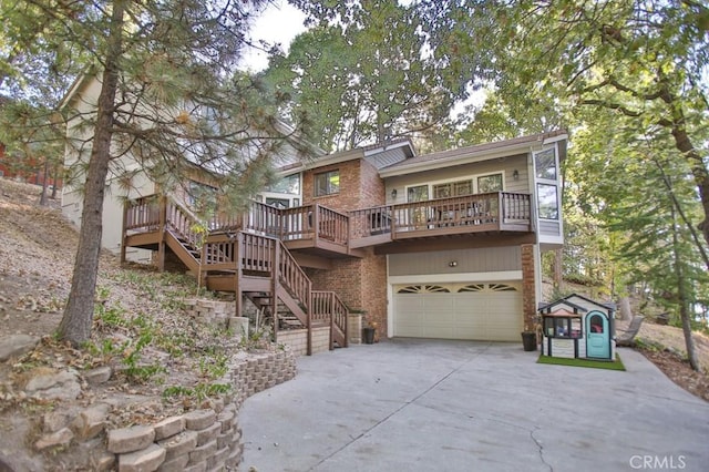 rear view of house with brick siding, an attached garage, driveway, a wooden deck, and stairs