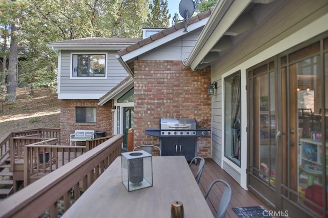 wooden deck featuring a grill