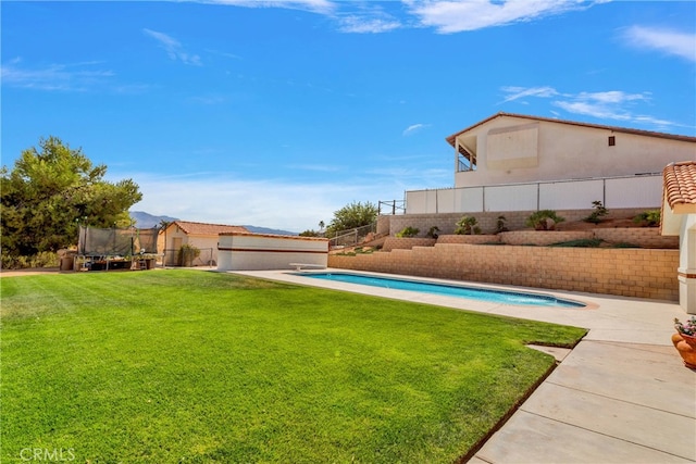 view of yard featuring a trampoline, a patio area, and a fenced in pool