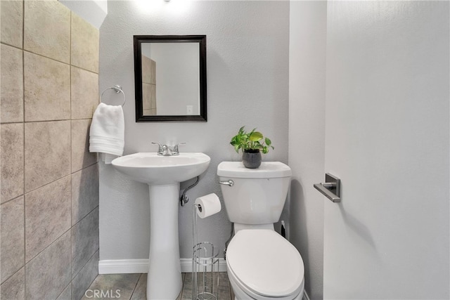 bathroom with tile patterned flooring, sink, and toilet