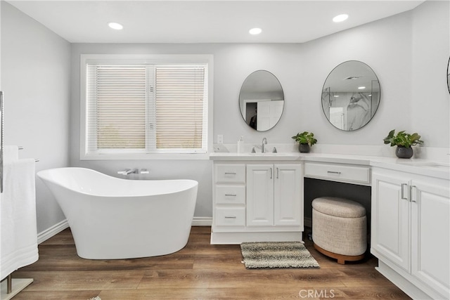 bathroom featuring hardwood / wood-style floors, vanity, and a bathing tub