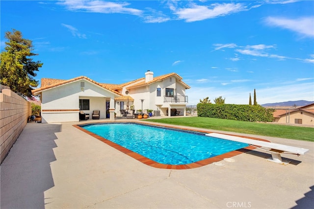 view of pool featuring a diving board, a yard, and a patio area