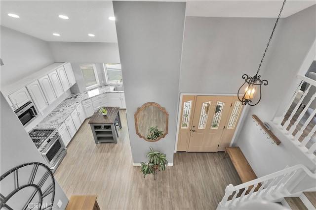 foyer entrance with an inviting chandelier and light wood-type flooring