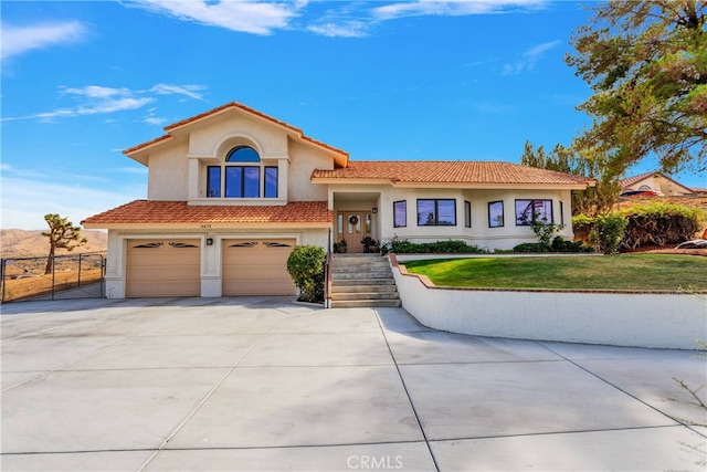 mediterranean / spanish-style house featuring a front yard and a garage