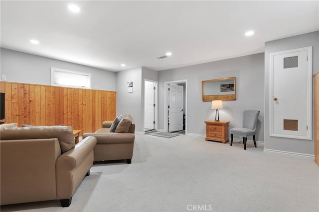 carpeted living room with wooden walls