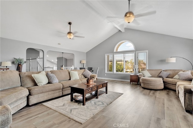 living room with beamed ceiling, high vaulted ceiling, light hardwood / wood-style flooring, and ceiling fan