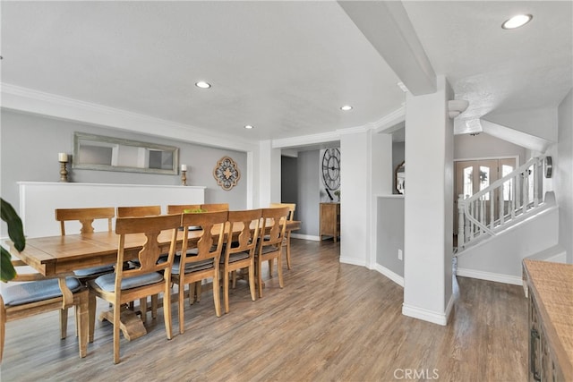 dining space featuring crown molding and light hardwood / wood-style flooring