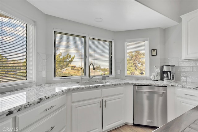 kitchen featuring sink, plenty of natural light, stainless steel dishwasher, and white cabinets