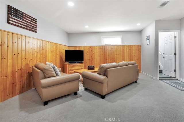 living room with light carpet and wood walls