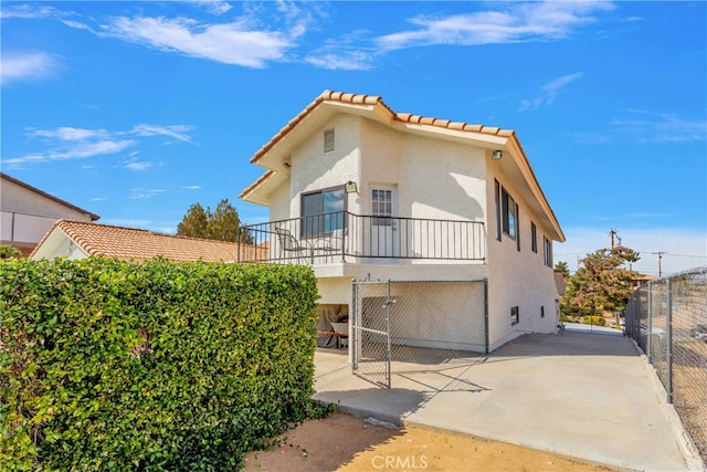 back of house with a balcony and a patio area