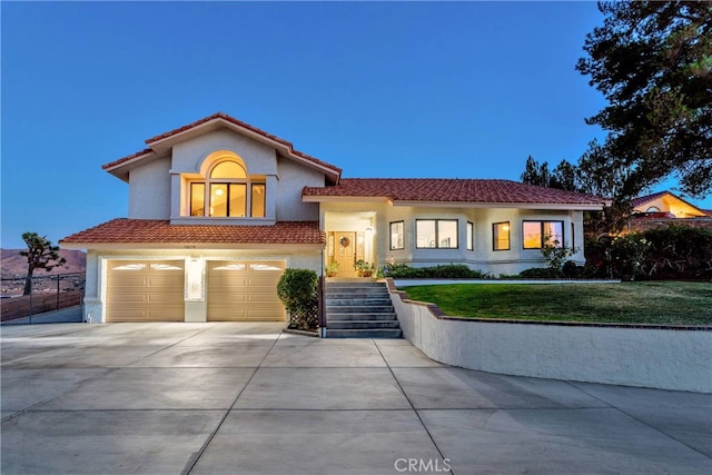 mediterranean / spanish home featuring a lawn and a garage