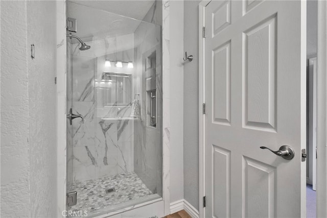 bathroom featuring a shower with shower door