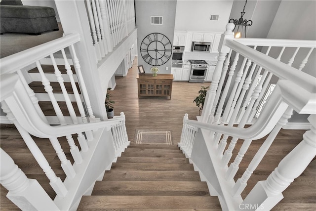 stairs featuring a chandelier and hardwood / wood-style flooring