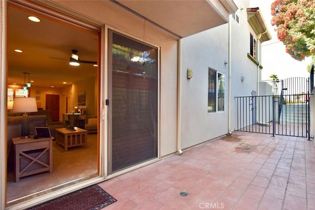 entrance to property featuring stucco siding, a patio, and a gate